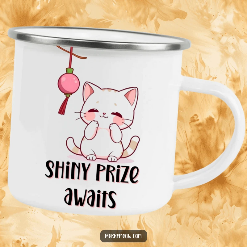 Funny camping mug showing a cat character gleefully batting at a dangling Christmas ornament, perfect for outdoor holiday cheer.