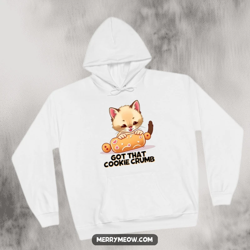 Funny hoodie featuring an energetic Siamese kitten intensely focused on playing with a runaway gingerbread cookie, radiating fun.