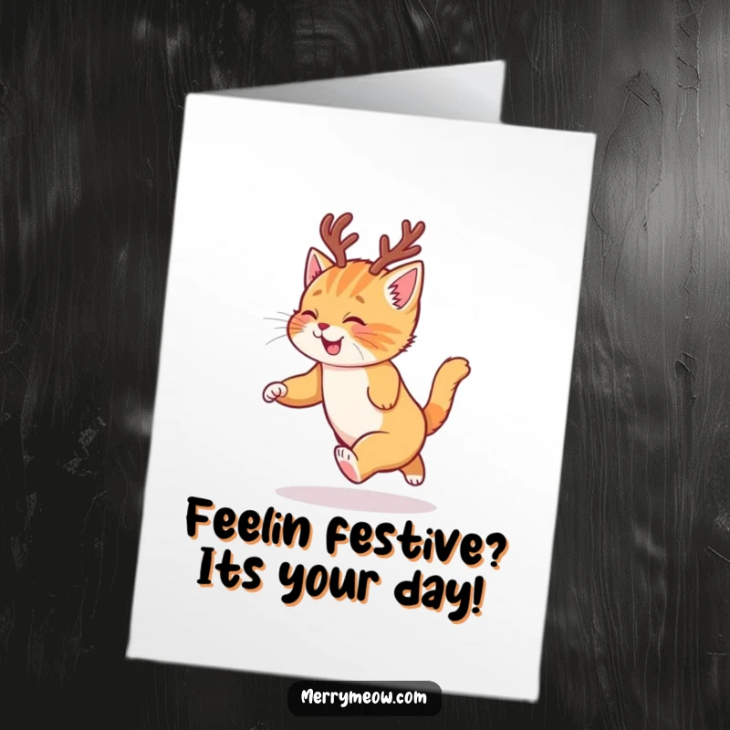 Funny Free Printable Birthday Card: A ginger kitten in reindeer antlers joyfully chases its tail, spreading birthday cheer.