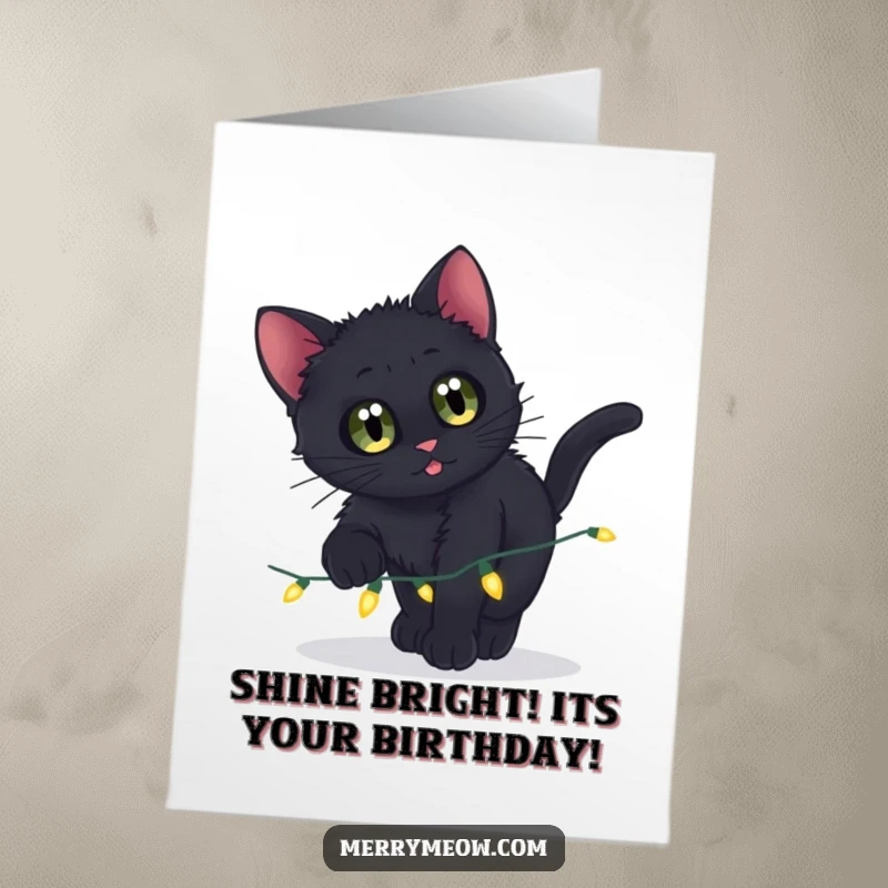 Funny Free Printable Birthday Card: A curious black kitten with wide eyes pounces playfully on a string of twinkling lights.