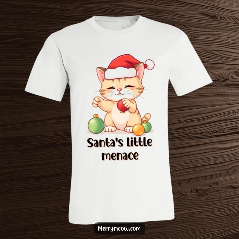 Funny festive cat t-shirt showing a joyful cat in a small Santa hat, actively playing with dangling Christmas ornaments.