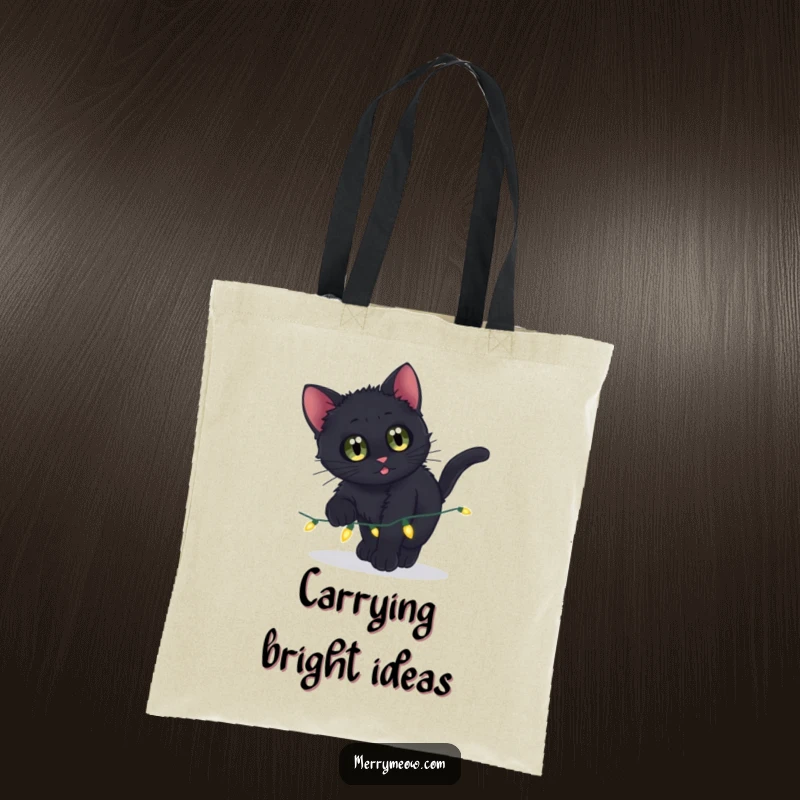 Funny tote bag featuring a black kitten with curious eyes attacking a string of twinkling lights.