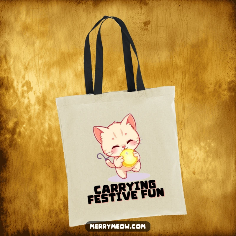 Funny tote bag with a kitten joyfully chasing a glowing holiday ornament, perfect for carrying your festive items.