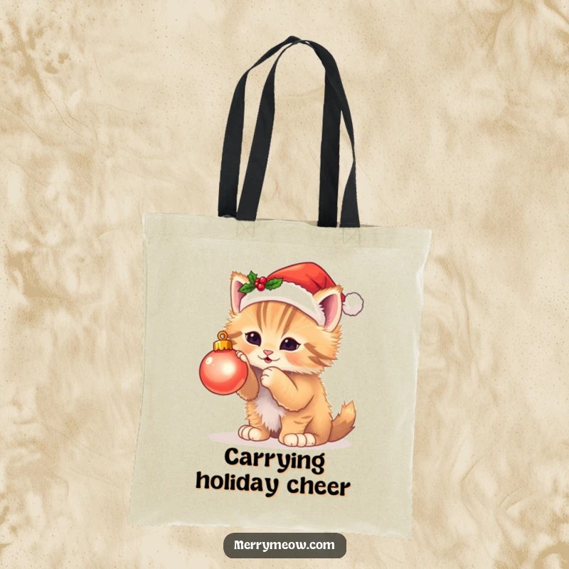 Funny tote bag with a fluffy kitten in a Santa hat playing with a twinkling Christmas ornament, perfect for holiday shopping.