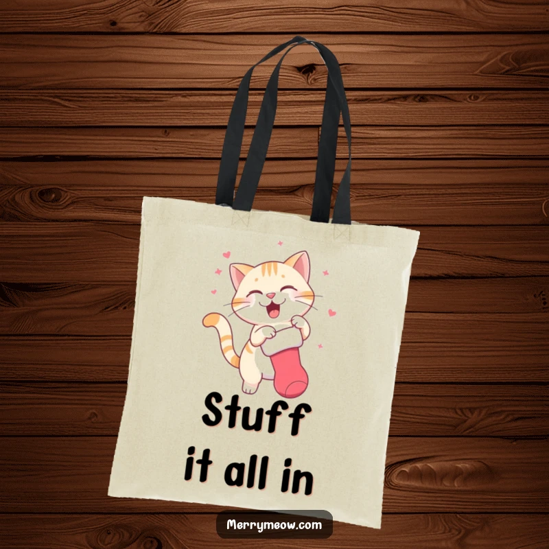 Funny tote bag with a lively illustration of a cat character enthusiastically swatting a dangling Christmas stocking, full of playful holiday energy.