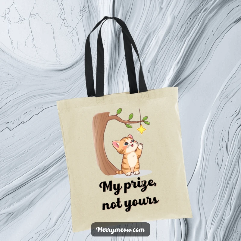 Funny tote bag with a charming tabby kitten enthusiastically chasing a sparkling star dangling from a whimsical tree, perfect for errands.